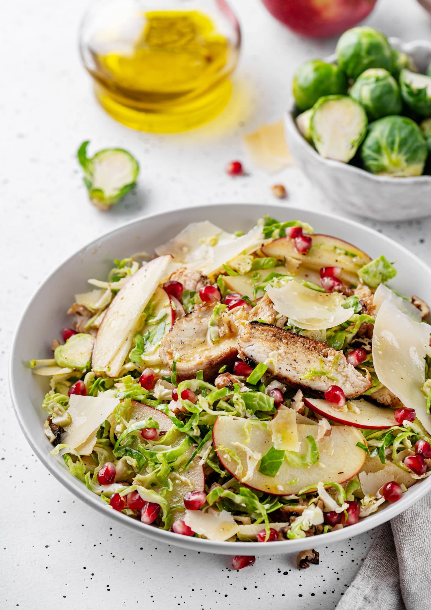 A bowl of brussels sprouts salad with oil on the side.