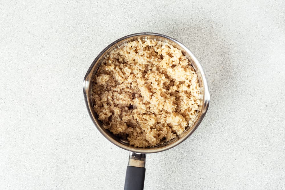 a silver pot filled with cooked quinoa.