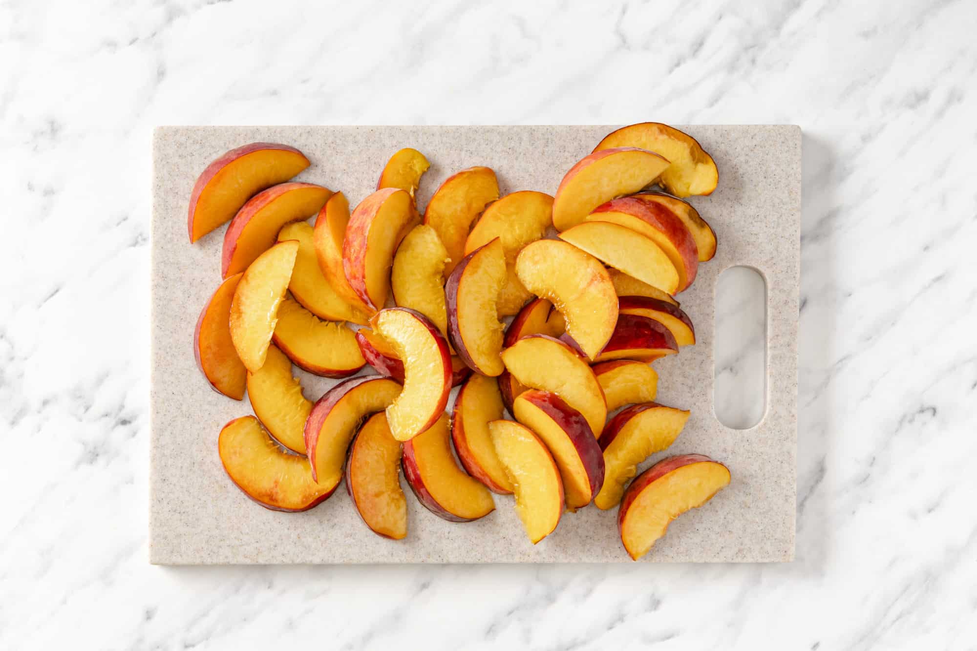 Sliced peaches on a cutting board.