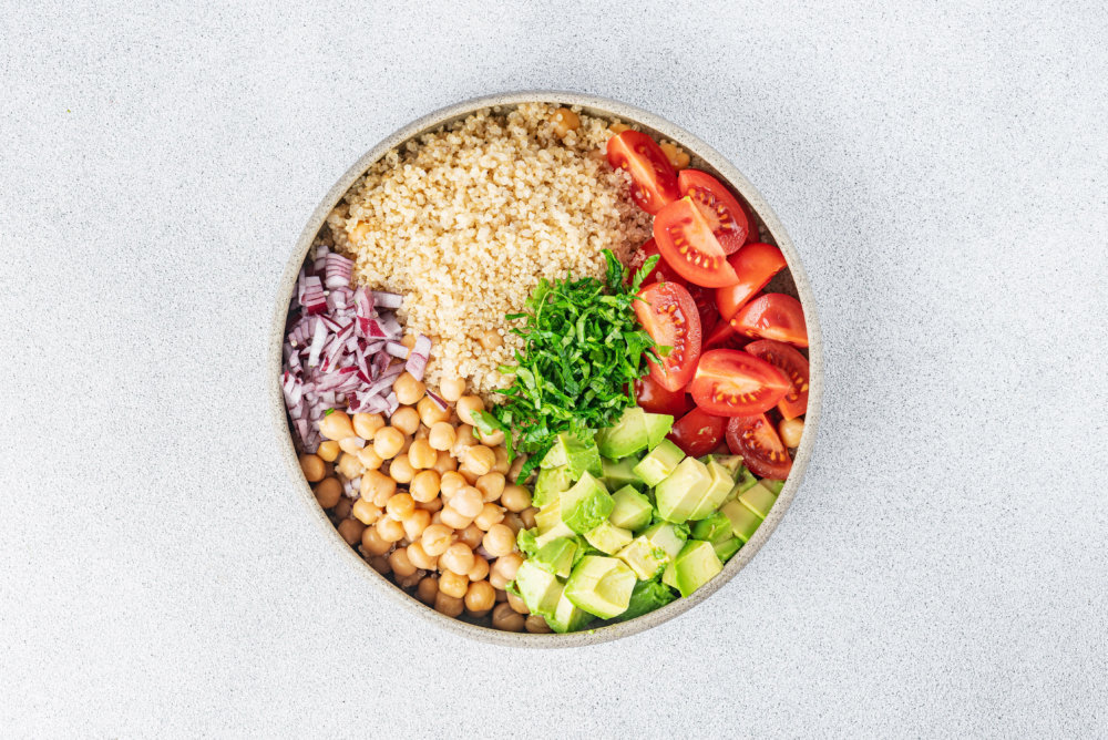 Quinoa chickpea salad ingredients in seperations in a bowl.