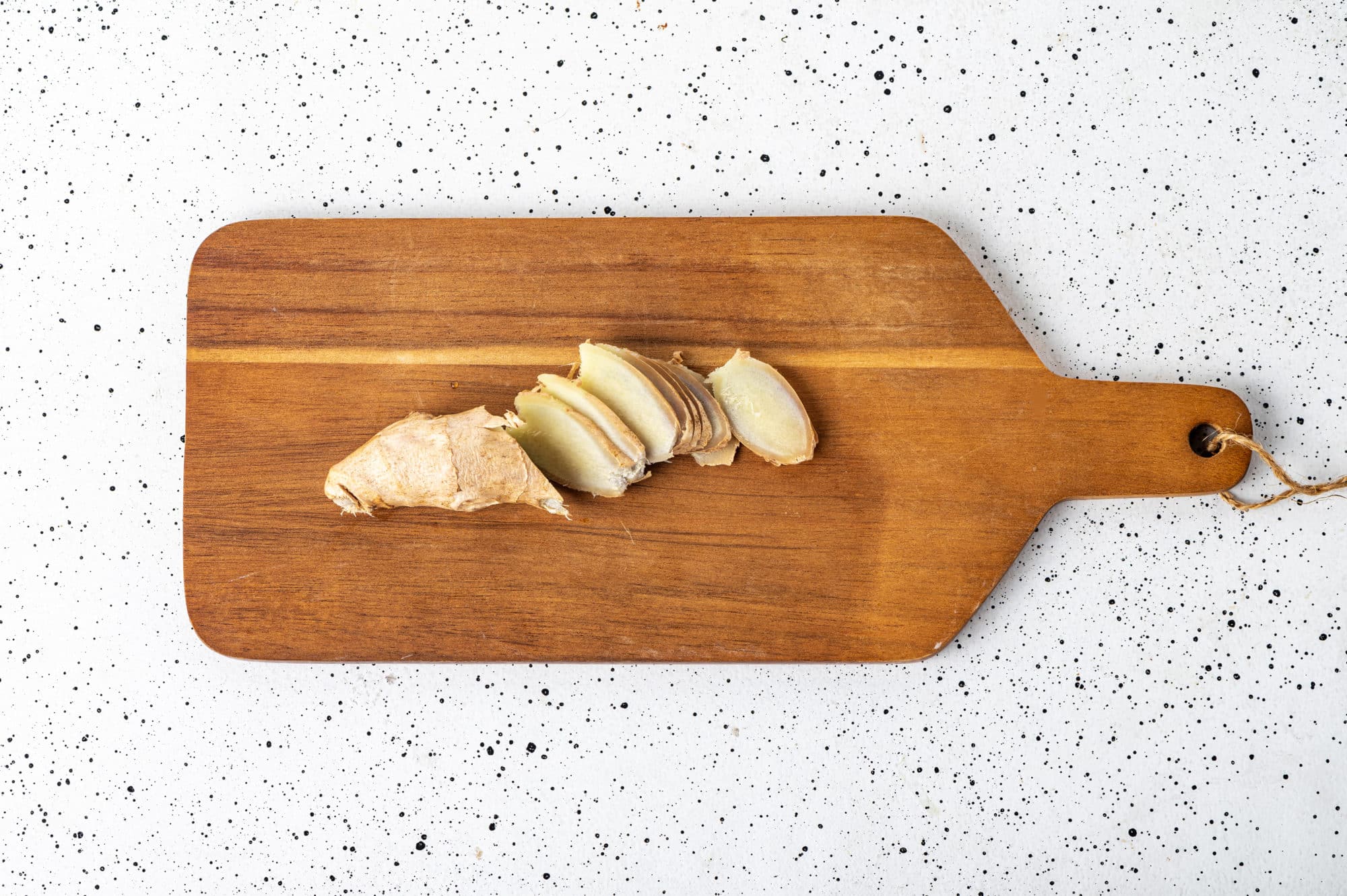 sliced ginger on a wooden board.