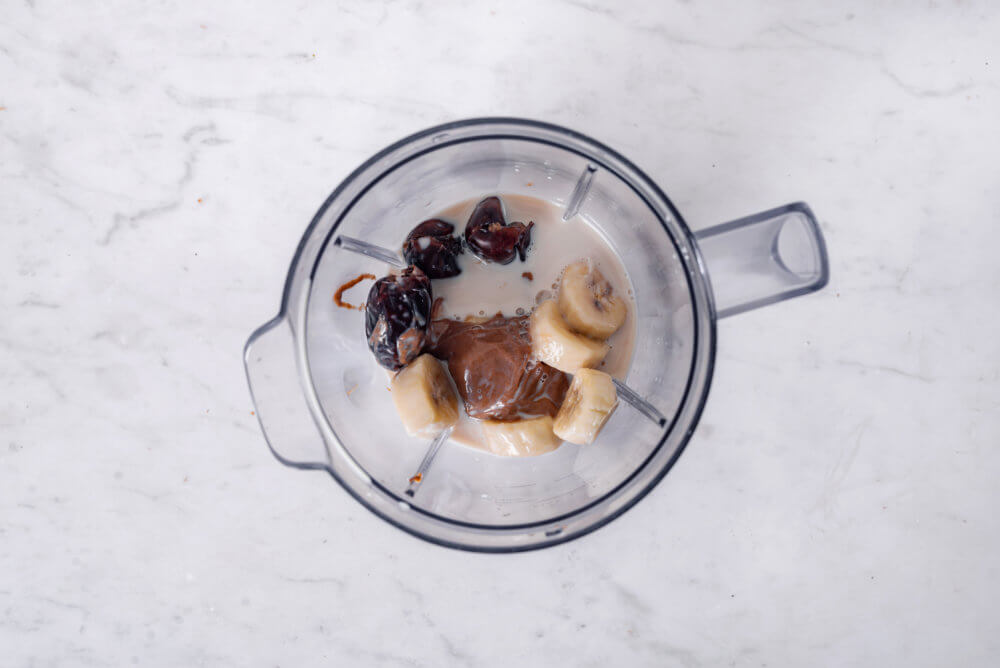 a blender filled with caramel smoothie ingredients.