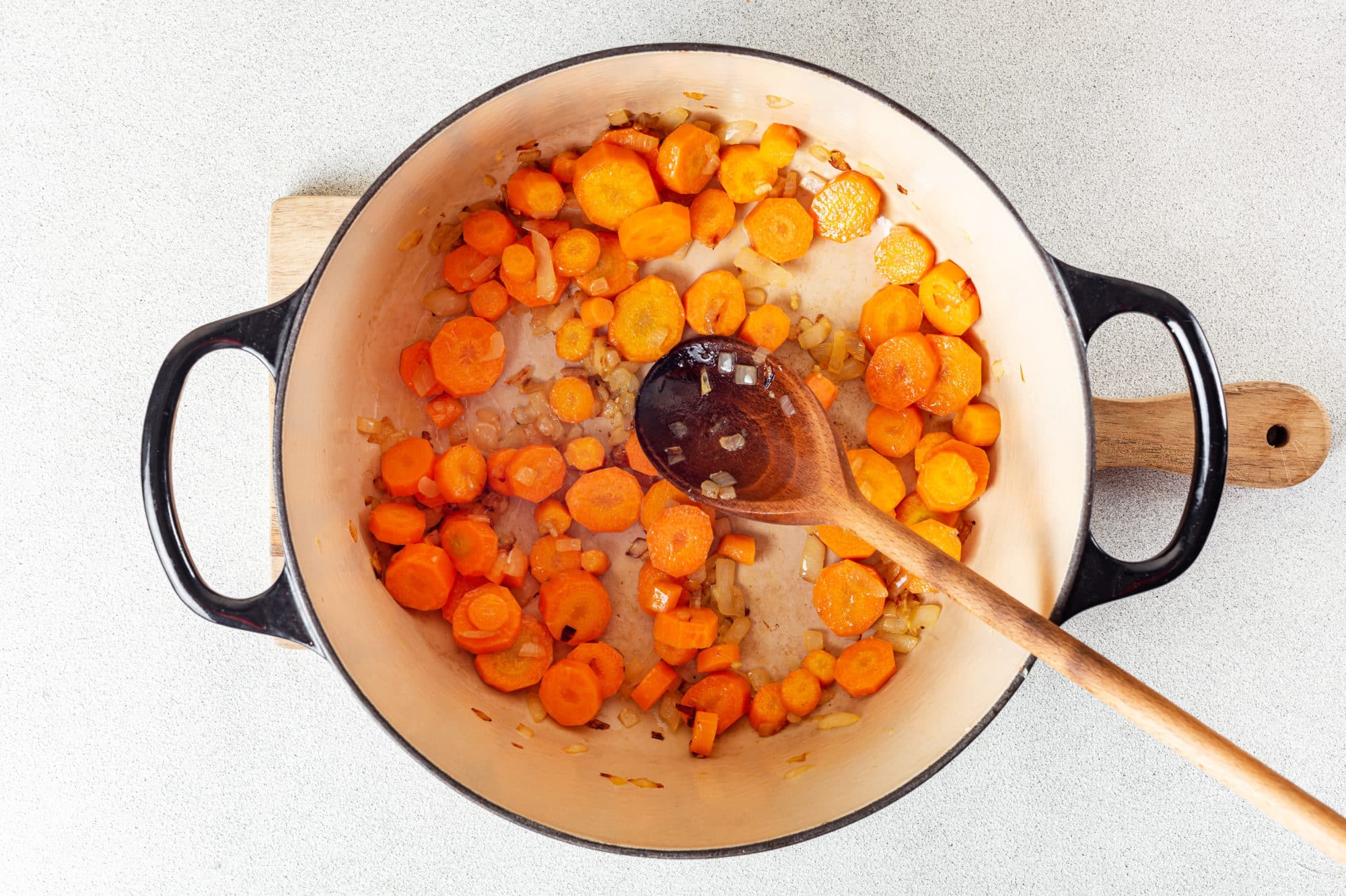 onion and carrot slices sauteeing in a large pot.