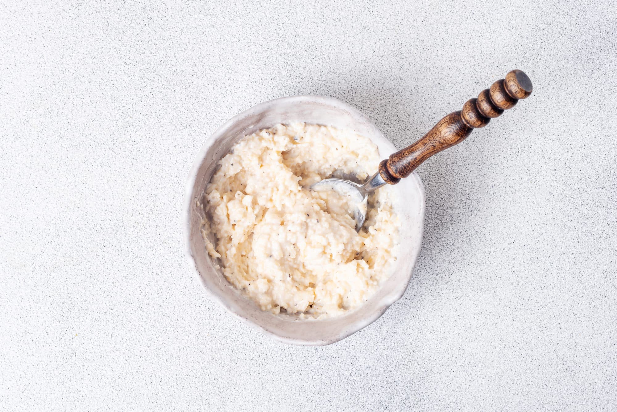 parmesan mix in a white bowl with a spoon.