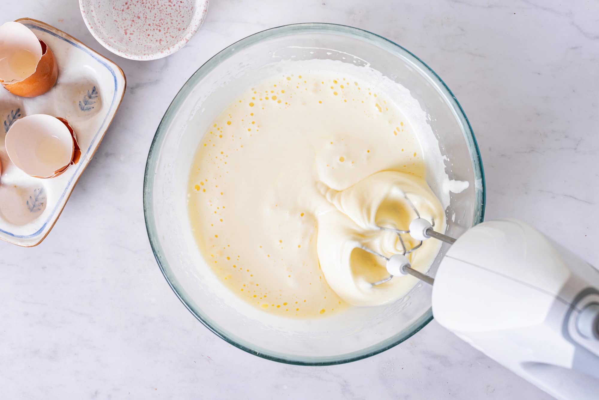 eggs and sugar in a bowl mixed with a hand mixer. 