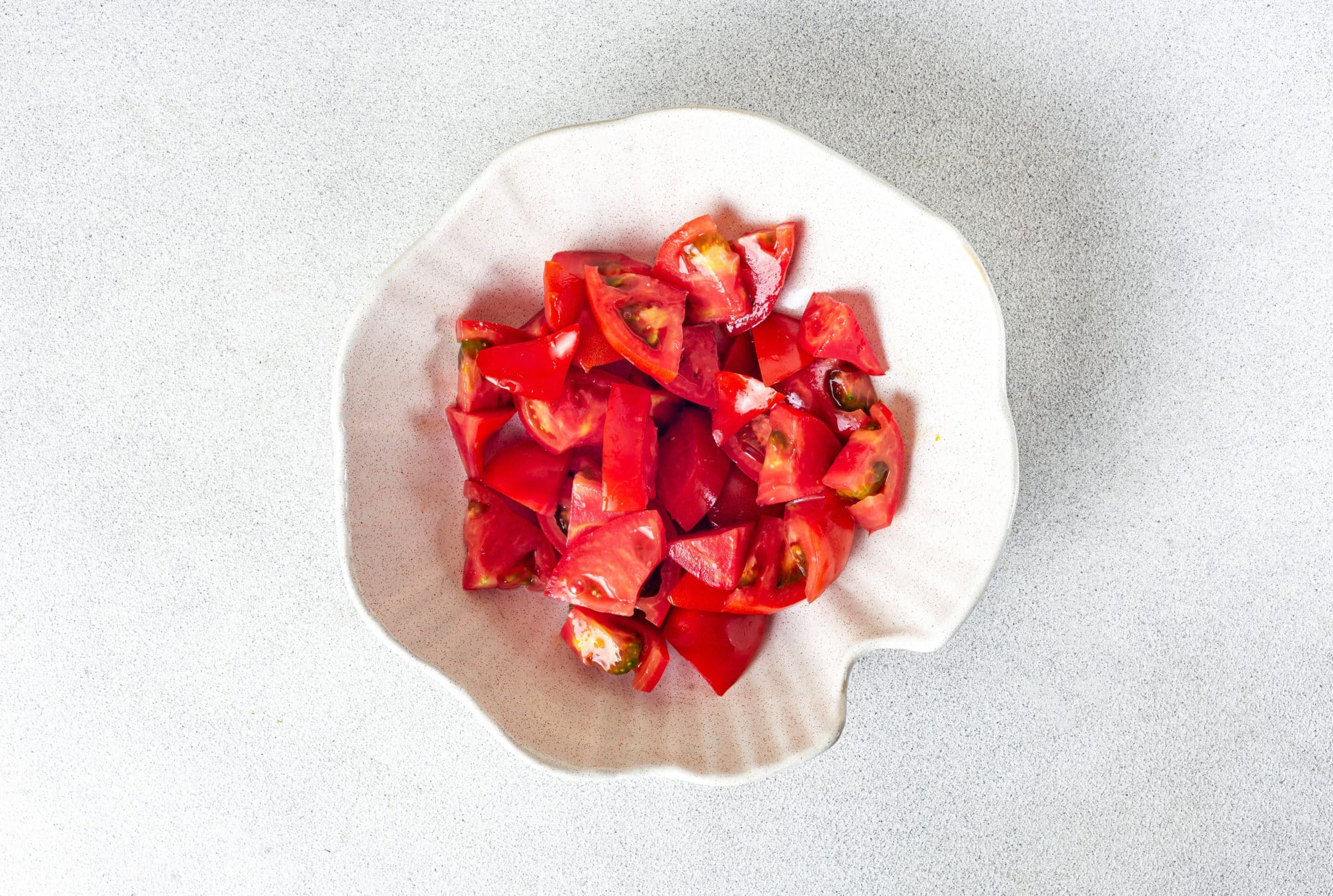 Chopped tomatoes in a white bowl.