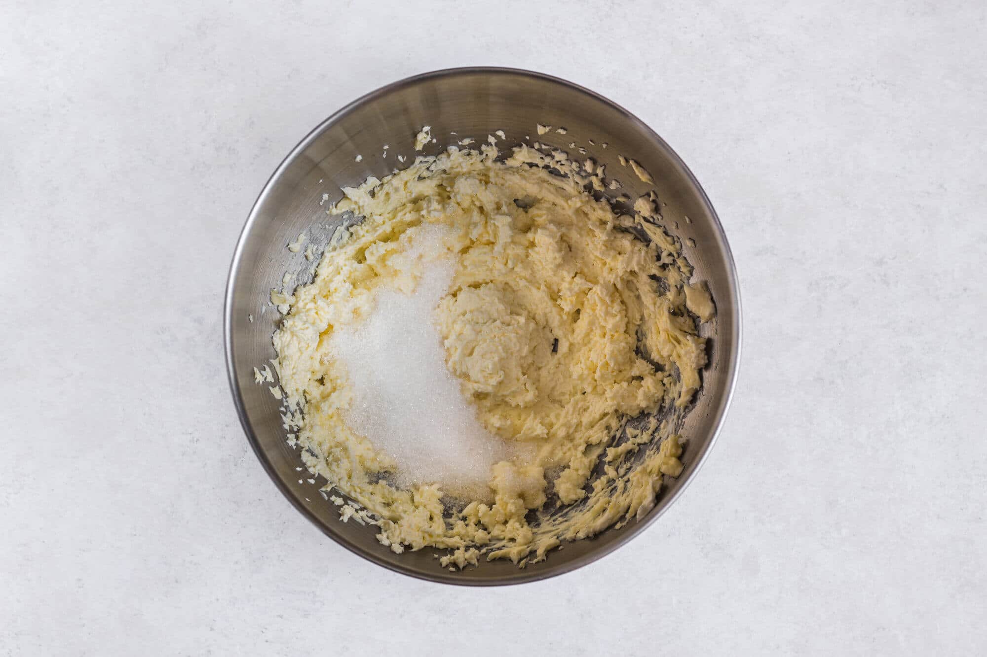 sugar-and-butter-being-mixed-in-a-silver-bowl