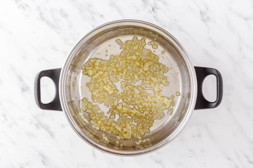 chopped onion sauteing in a soup pot.