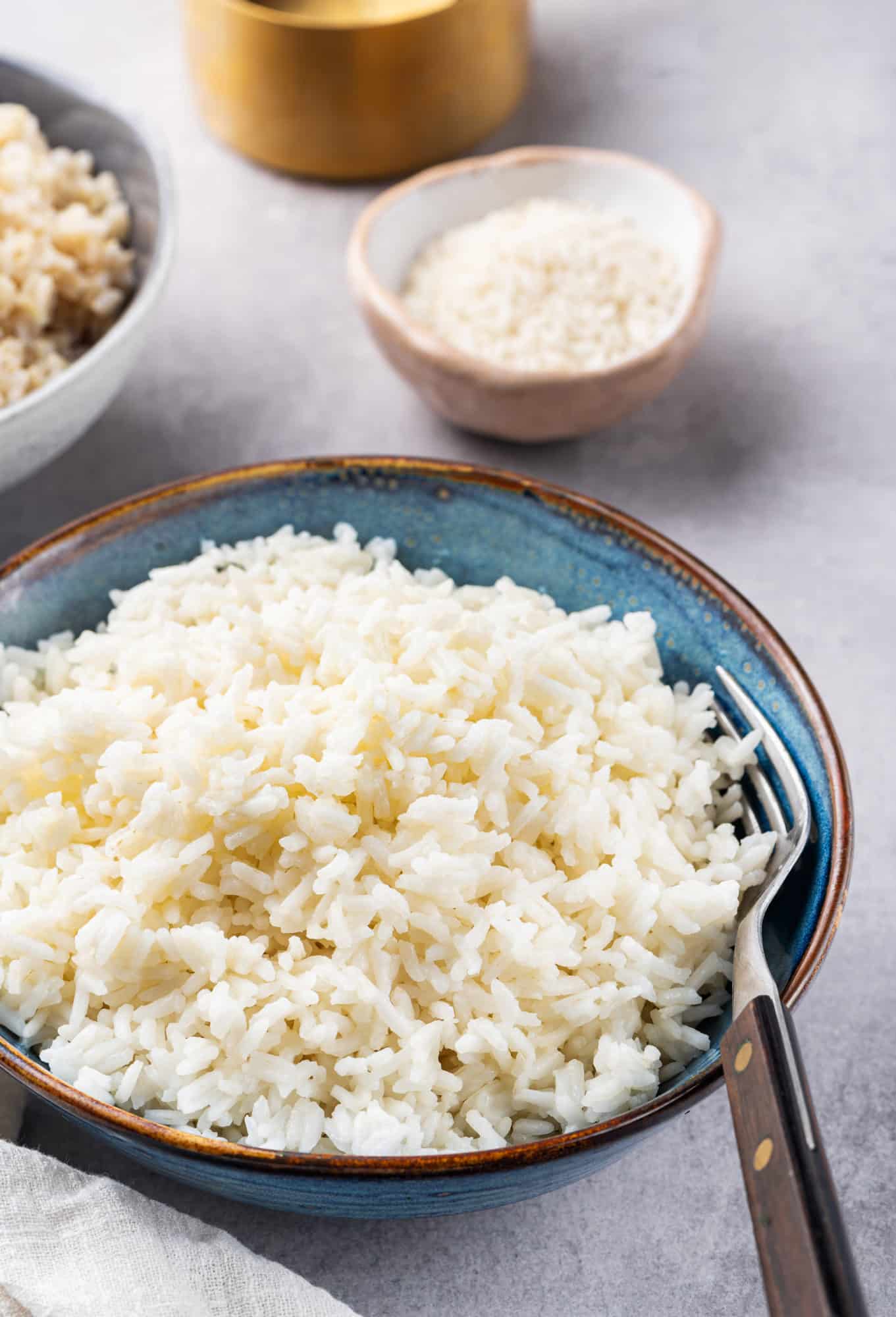 Rice in a blue bowl with a fork on the side.