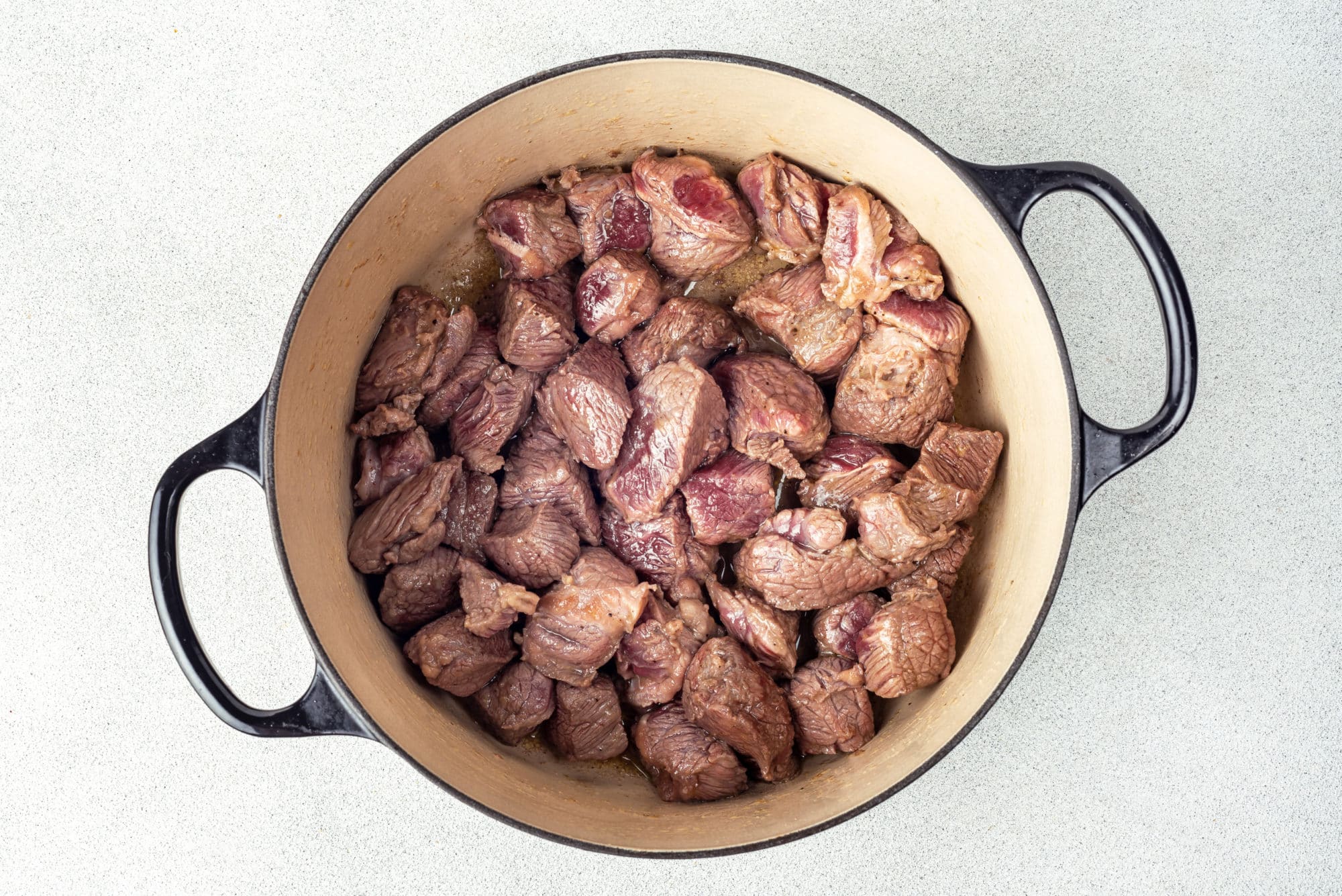 sauteed beef in a black pot.