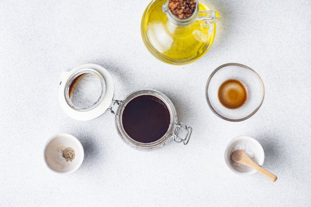 an ingredient spread for a dressing recipe olive oil salt black pepper and balsamic vinegar.