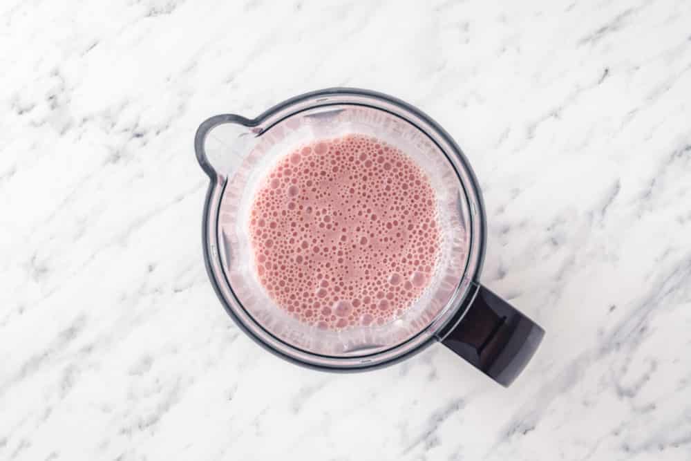 blended pomegranate smoothie in a blender top view.