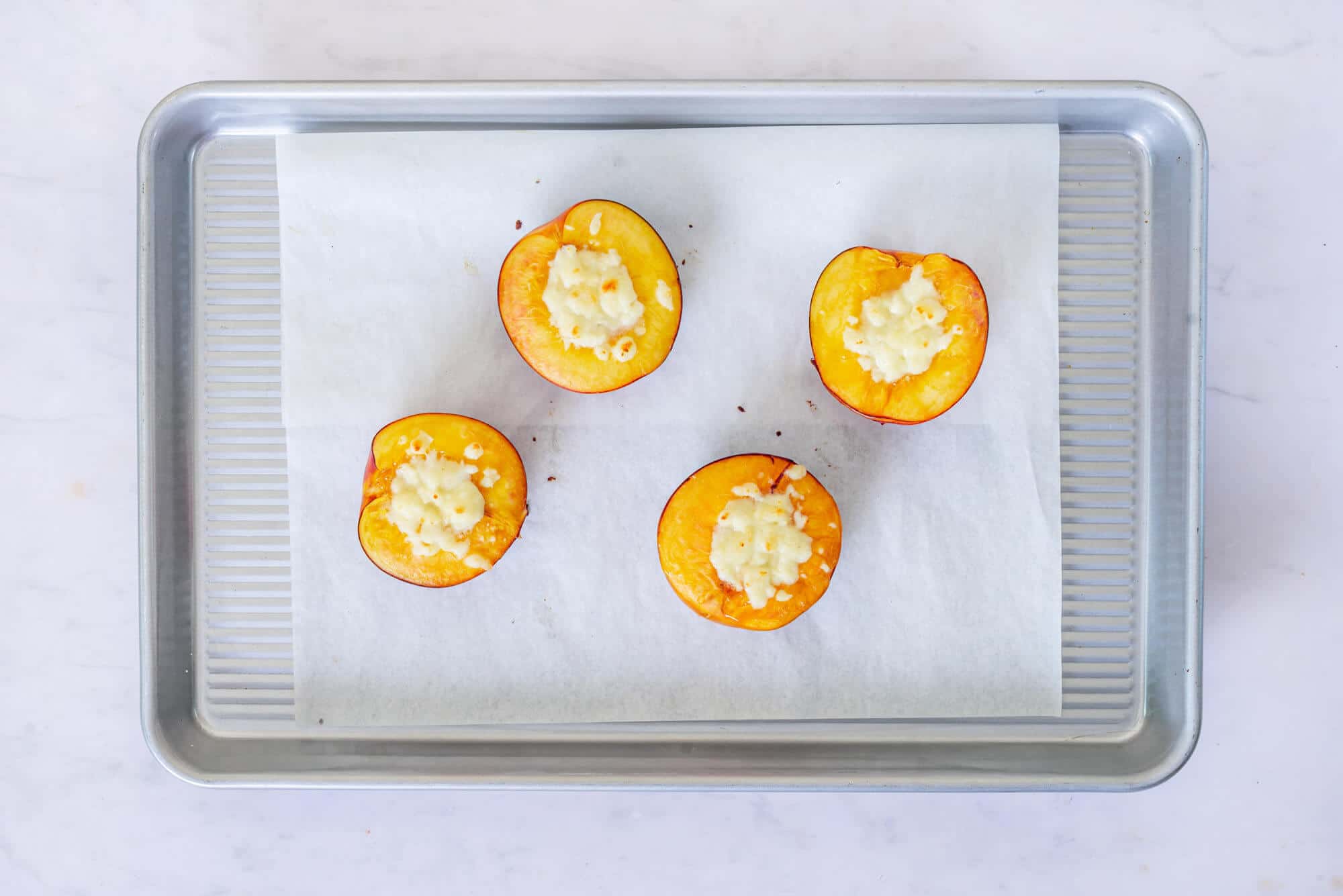 baked-nectarines-with-filling-on-parchment-paper-on-a-baking-tray