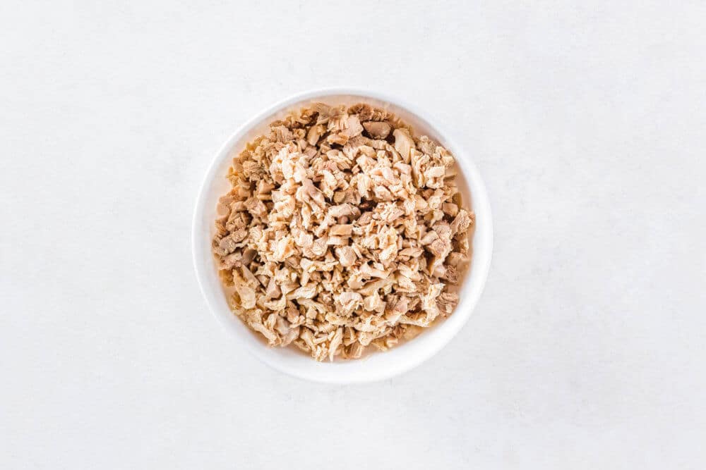 Shredded chicken in a white bowl.