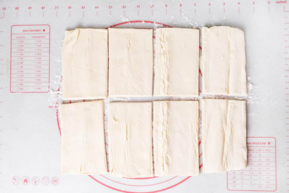 a baking mat with puff pastry slices on it.