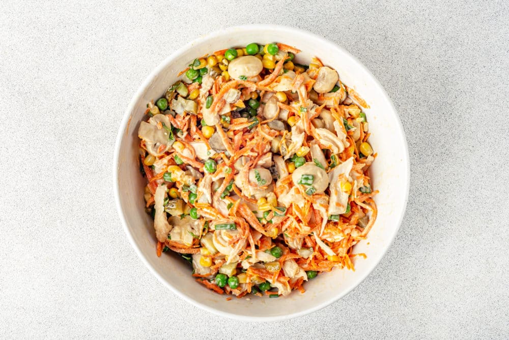 mixed chicken and veggie with mushrooms salad in a white bowl.