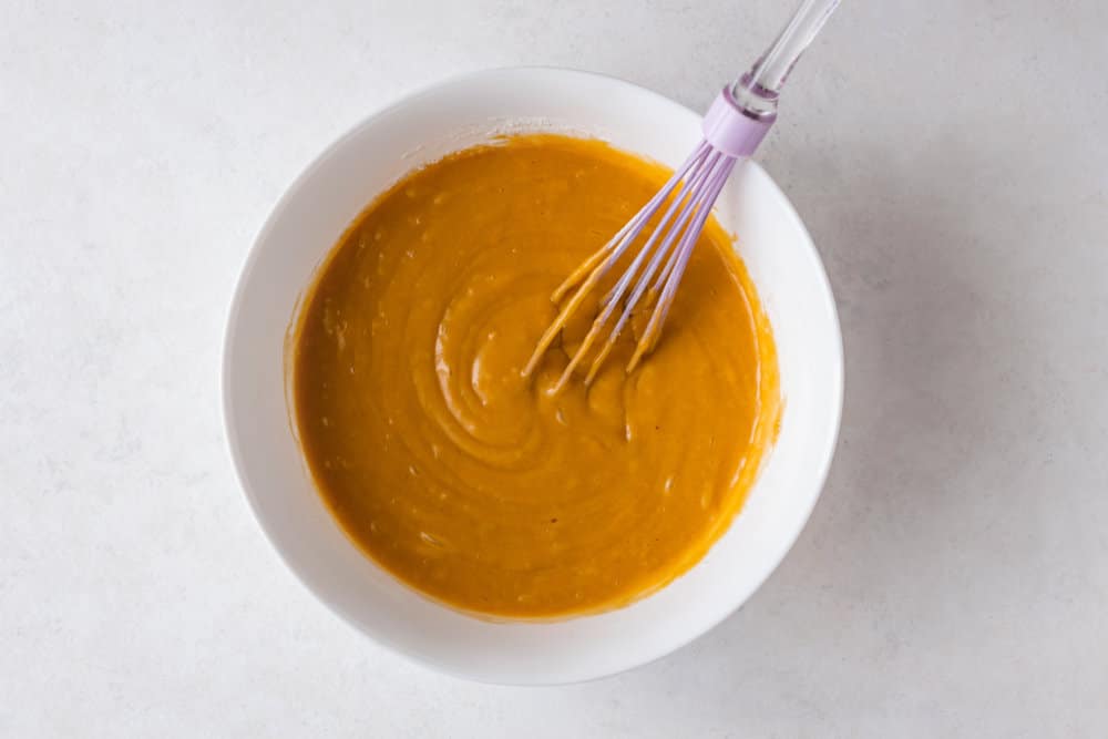 pumpkin-muffin-batter-in-a-white-bowl-with-a-whisk