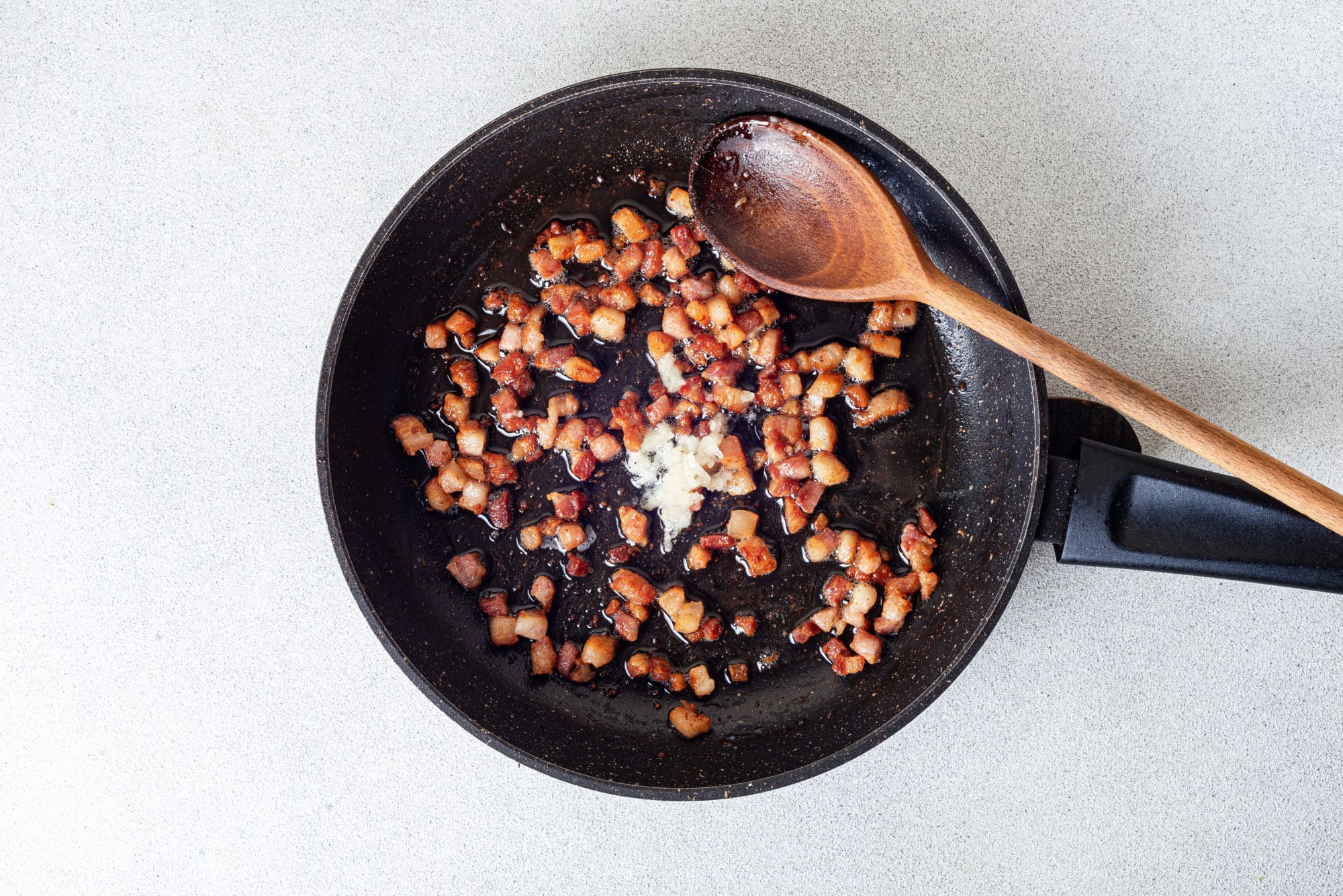 Sauteed pancetta dn garlic in a skillet.