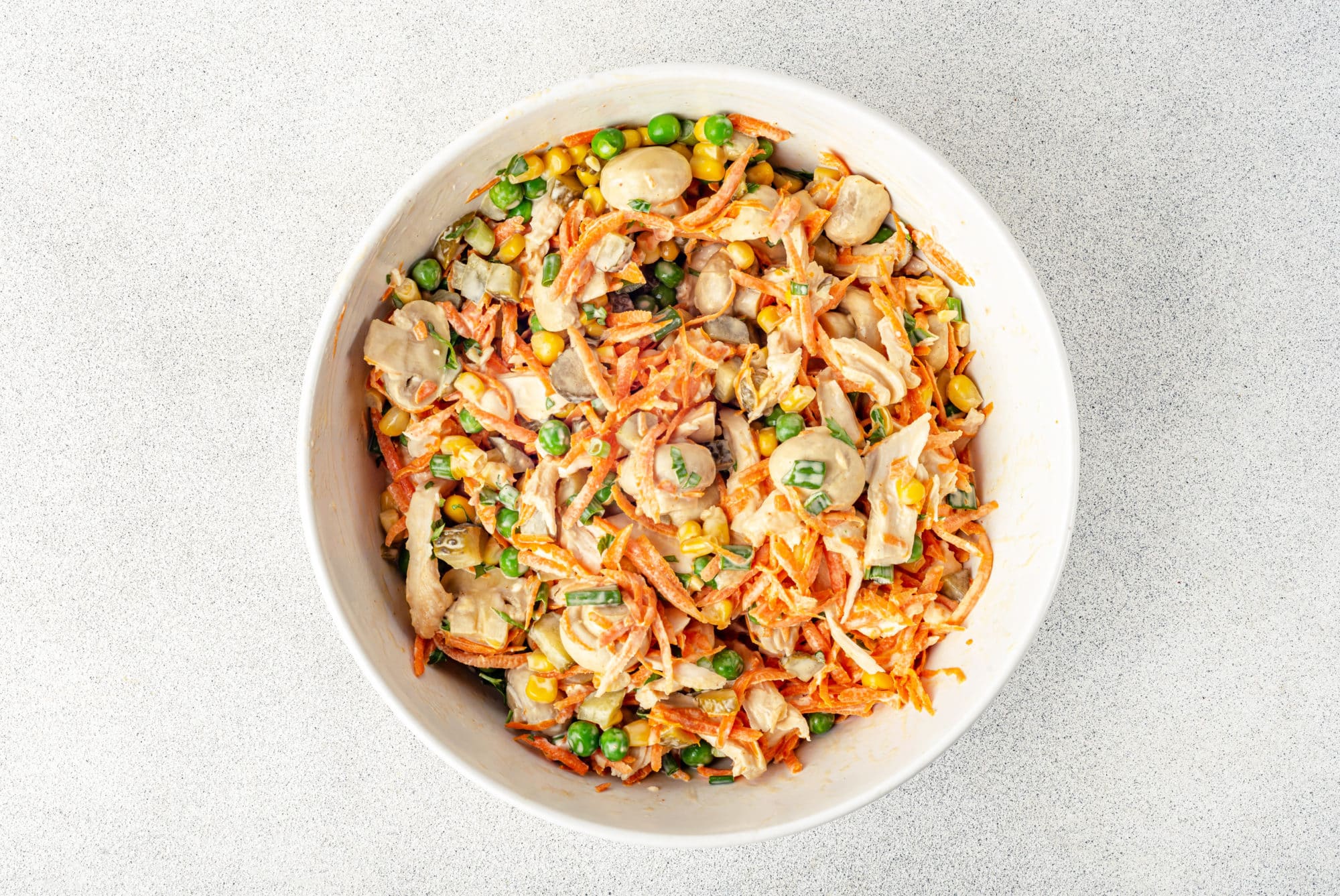 mixed chicken and veggie with mushrooms salad in a white bowl.