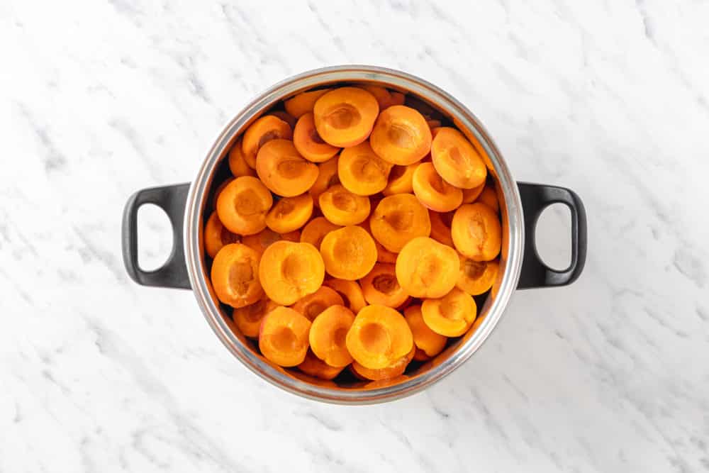 a pot filled with halved apricots.