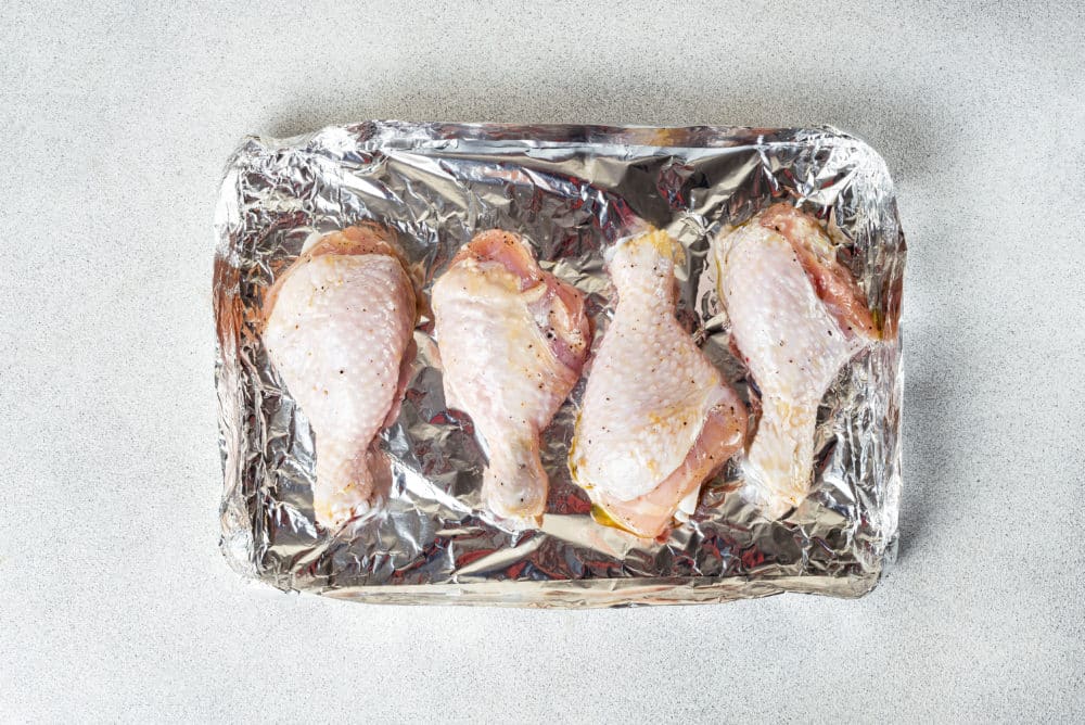 Chicken drumsticks on foil.