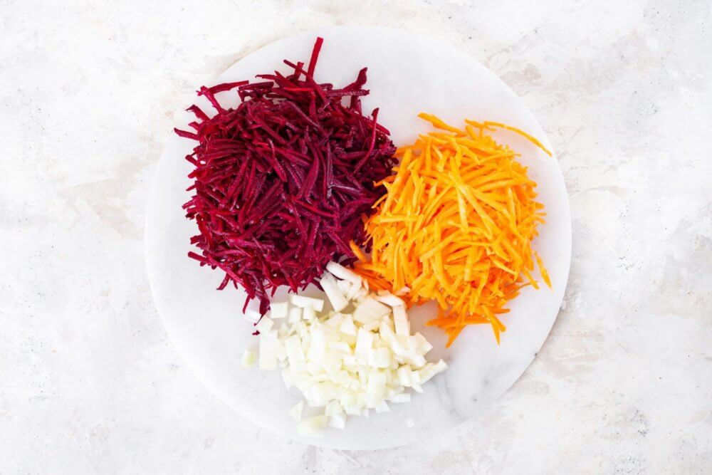 Shredded carrot, beet, and cabbage on a plate.