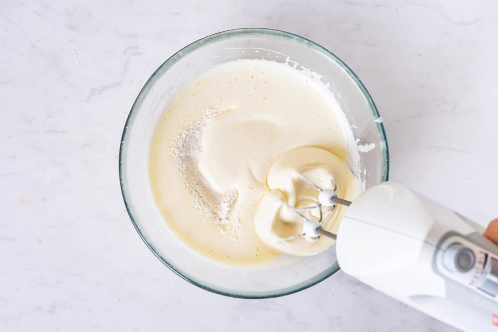 apple-cake-dough-in-a-clear-bowl-with-a-hand-mixer