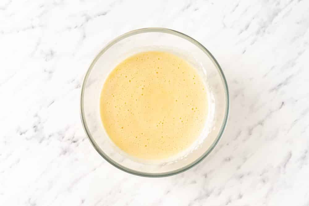 A glass bowl of mixed yellow cake batter.