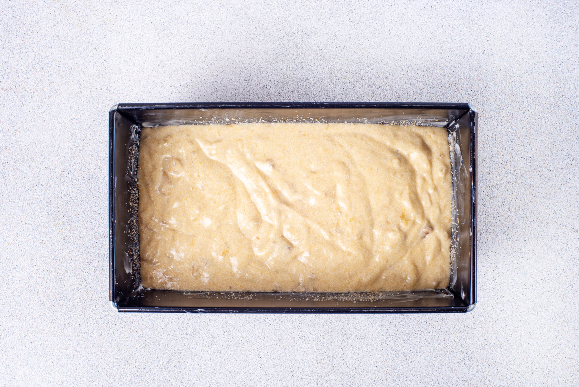 Banana bread batter in a loaf pan. 