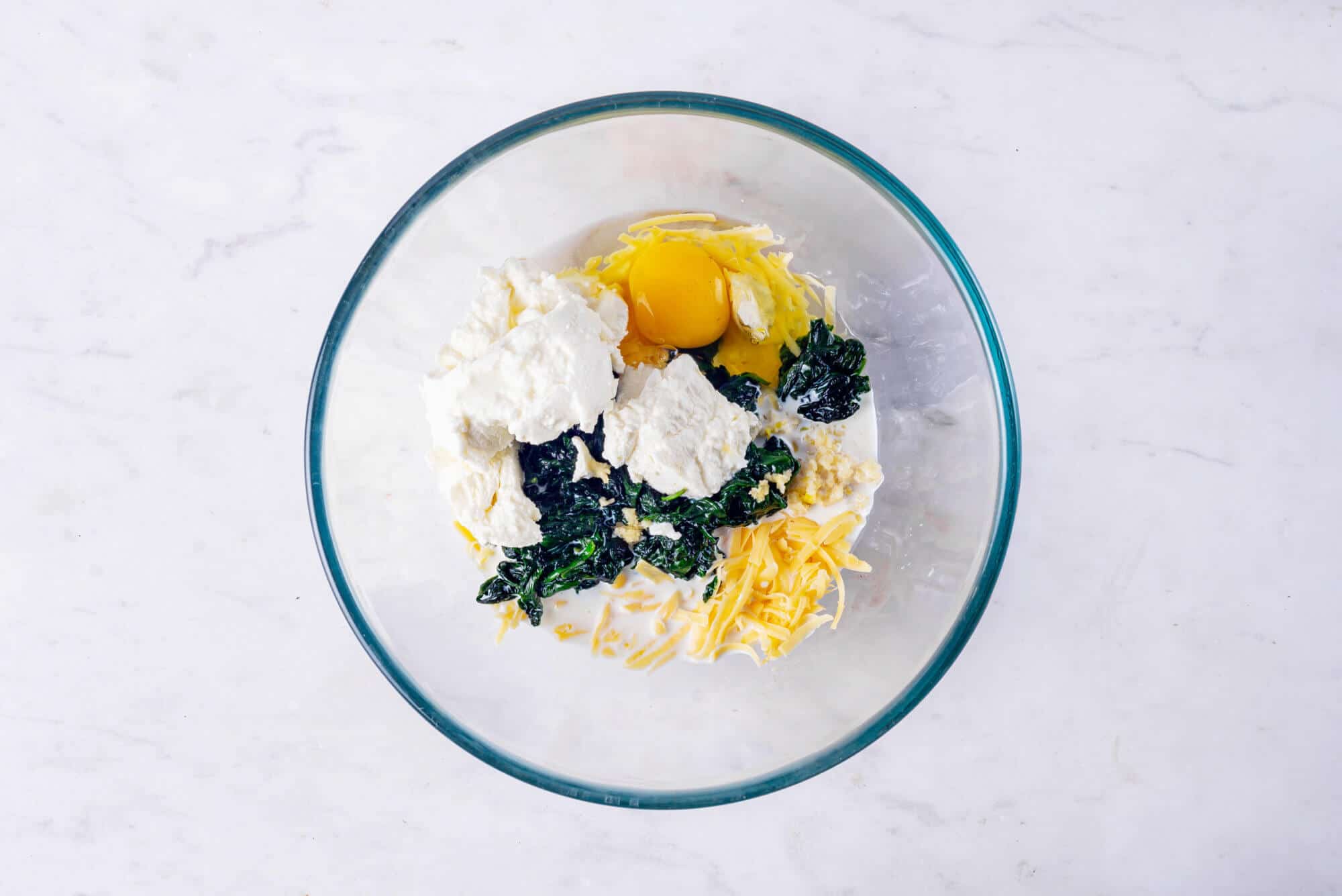 Spinach puff filling ingredients in a glass bowl. 