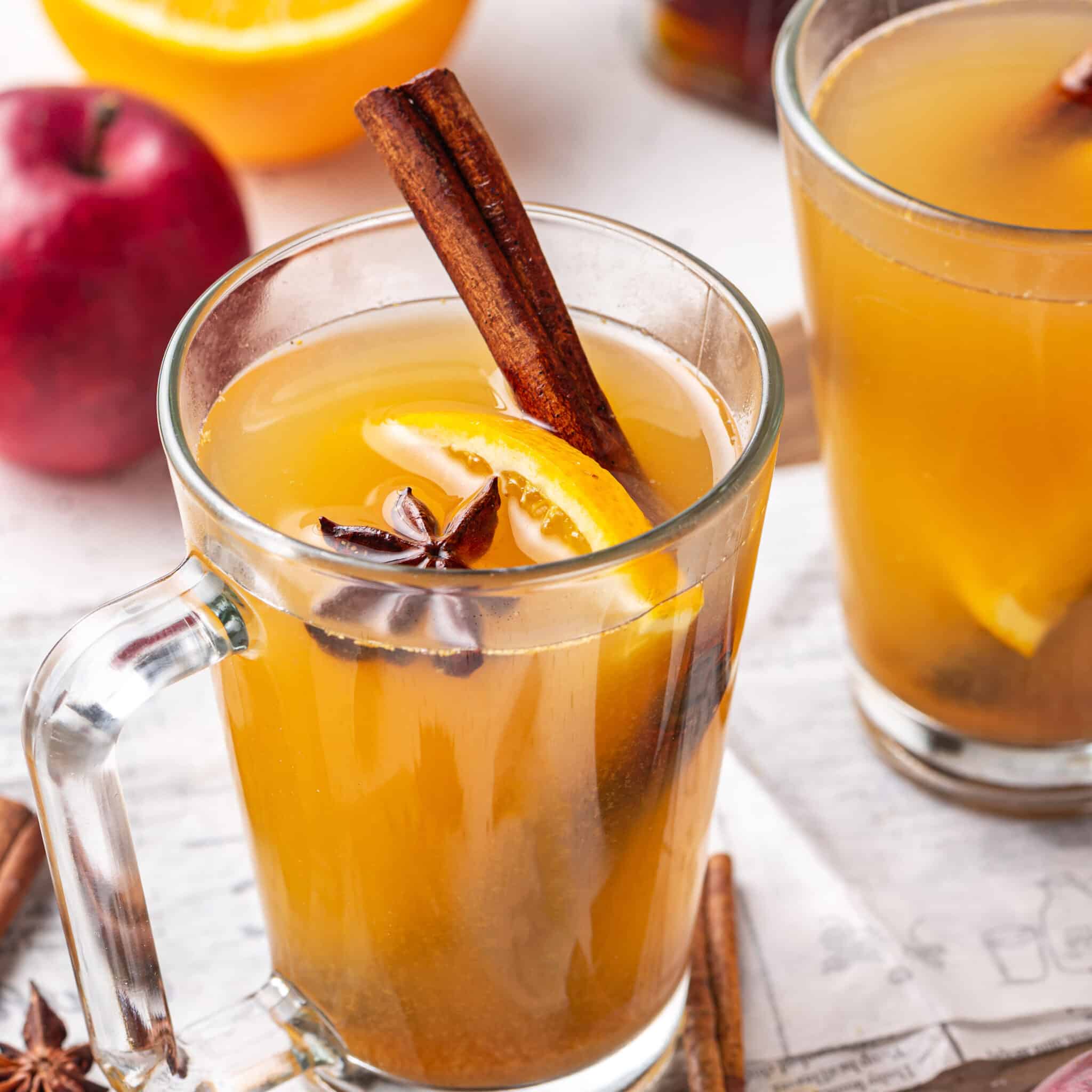 apple-cider-in-glasses-with-cinnamon-sticks-on-a-wooden-board