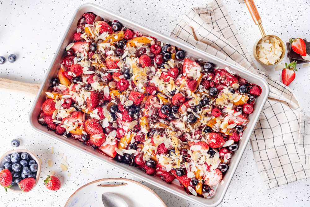 warm fruit salad in a baking sheet freshly baked on a towel.