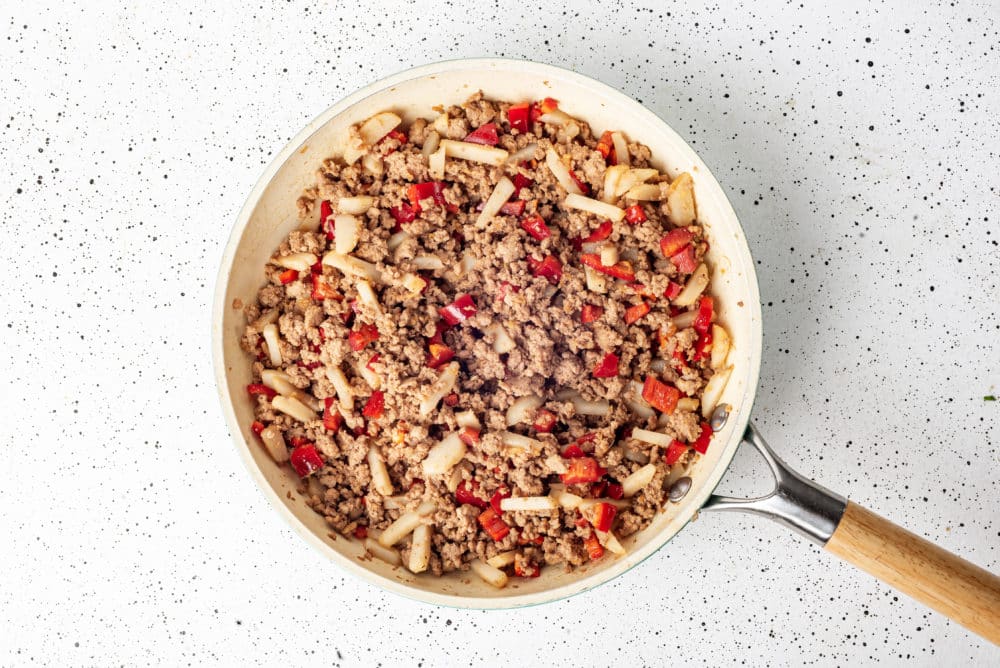 Veggies and ground turkey cooking in a skillet.