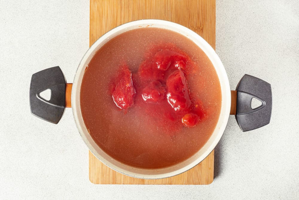 a pot filled with tomatoes and broth.