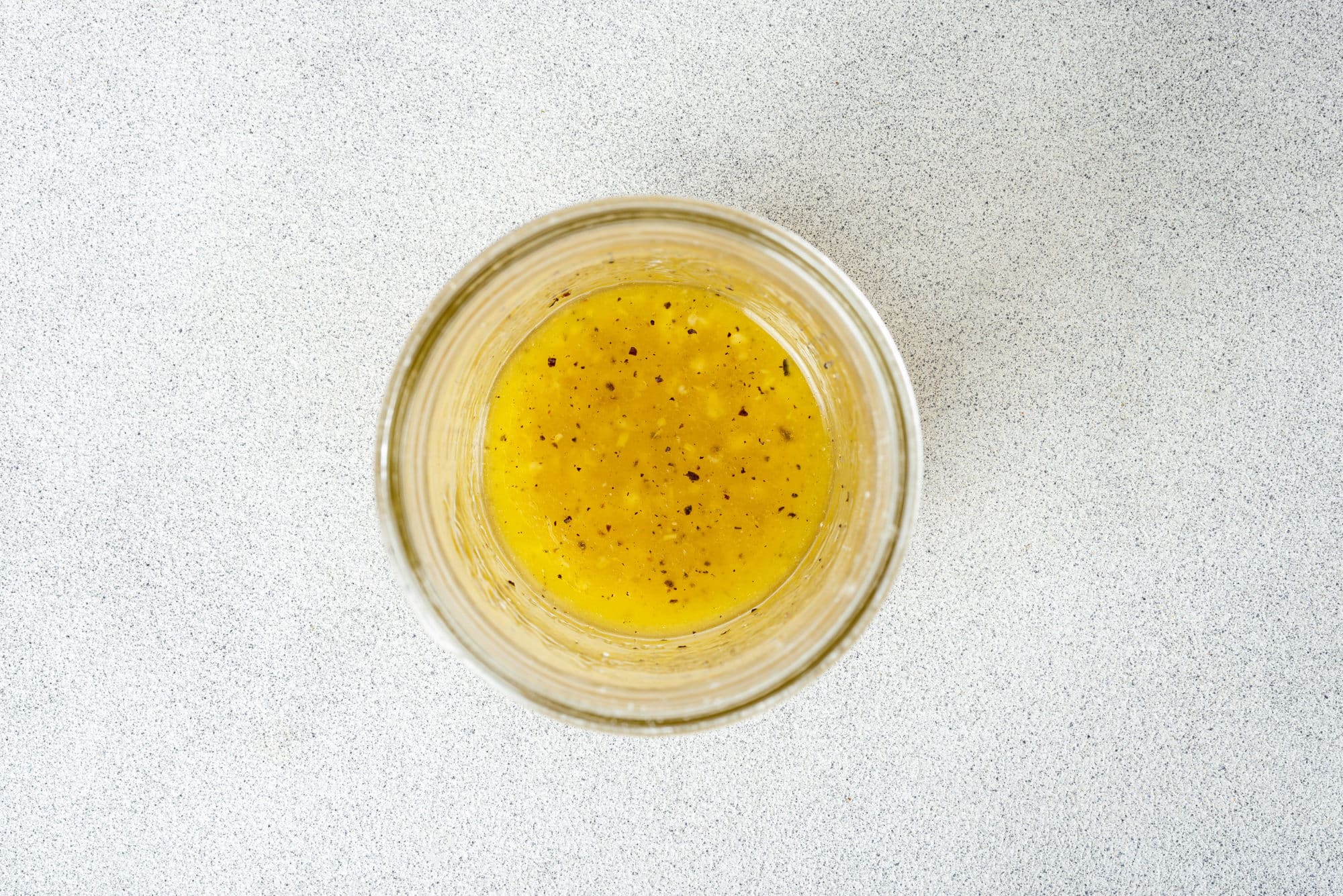 Lemon salad dressing in a glass bowl.