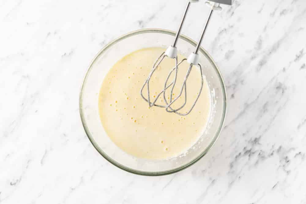 vanilla cookie batter in a glass bowl with hand mixers on the side.