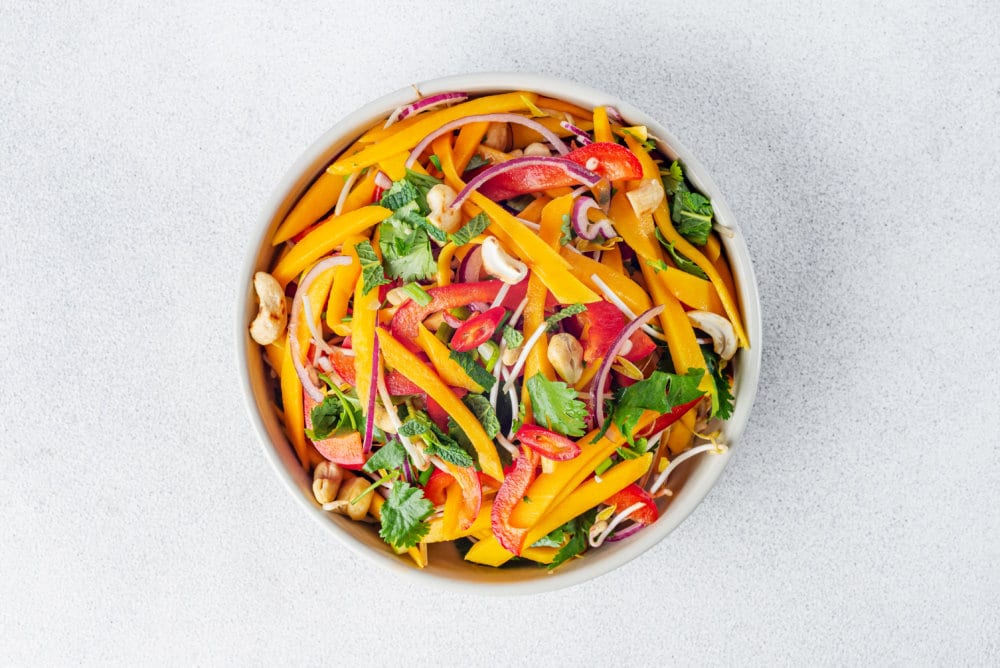 a white bowl filled with a mixed thai salad.