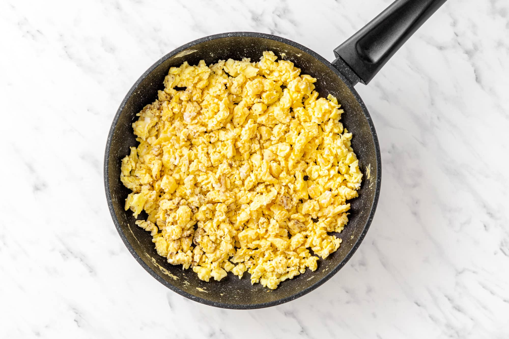 eggs scrambled and cooked in a pan.