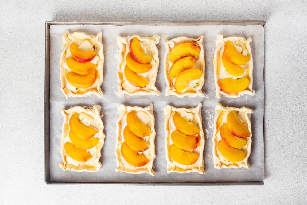 raw puff pastry tarts on a baking tray.