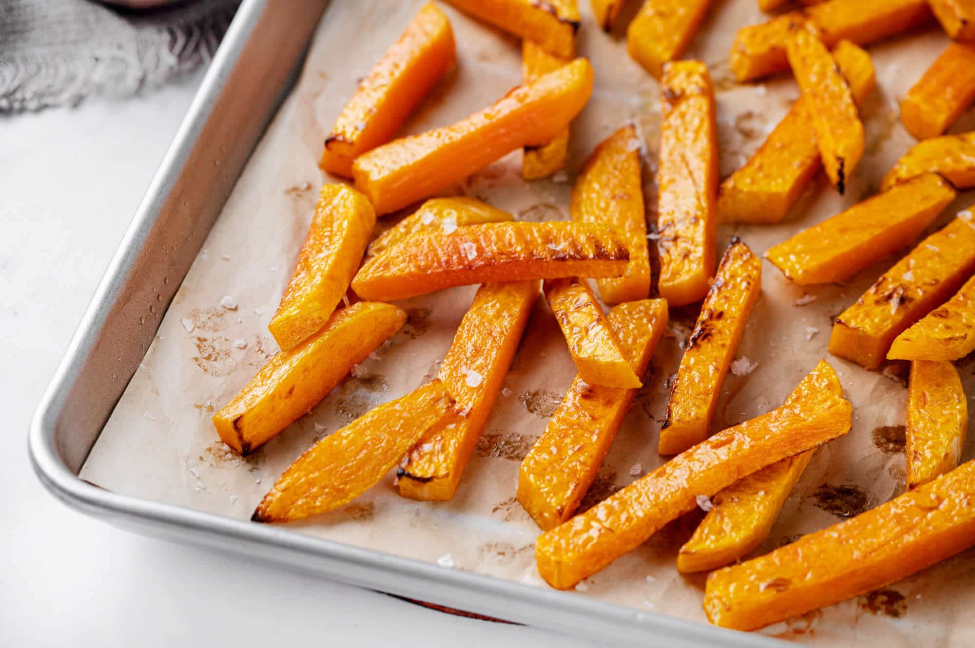 butternut-squash-fries-on-parchment-paper-on-a-baking-tray