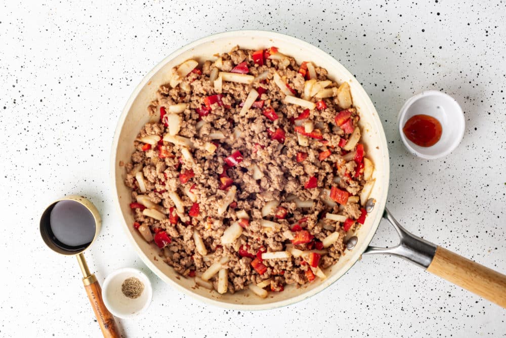 Turkey filling with other ingredients in a skillet with extra ingredient dishes on the side.