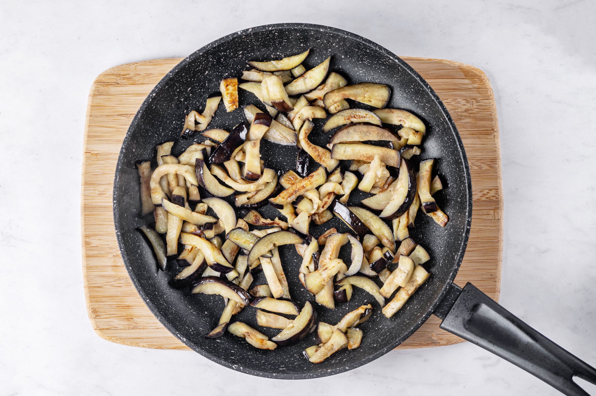 marinated-eggplants-in-skillet-on-wooden-cutting-board