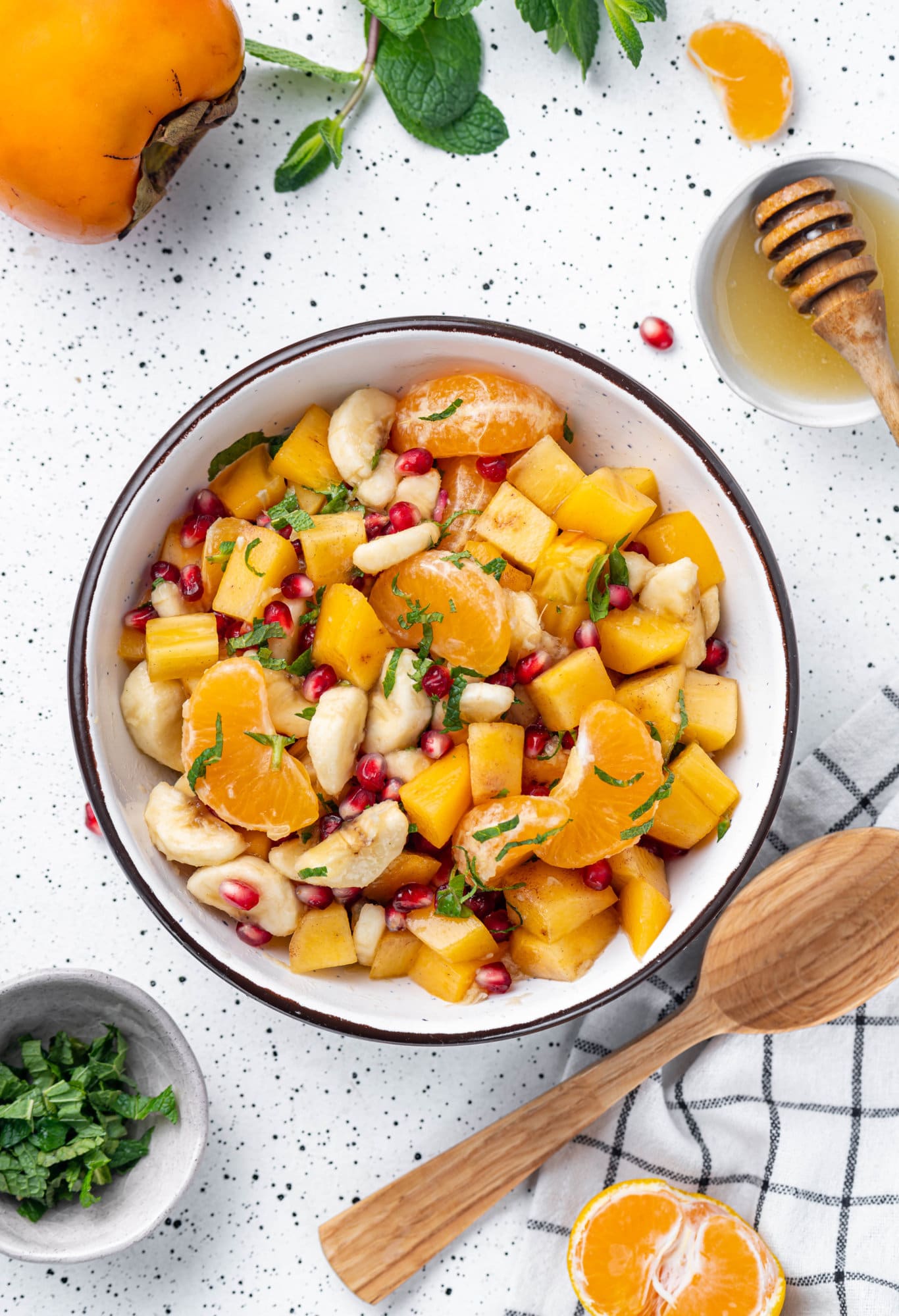 Persimmon fruit salad in a bowl with a black rim.