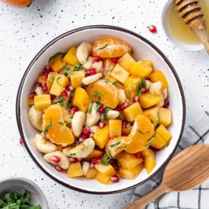 Persimmon fruit salad in a bowl with a black rim.