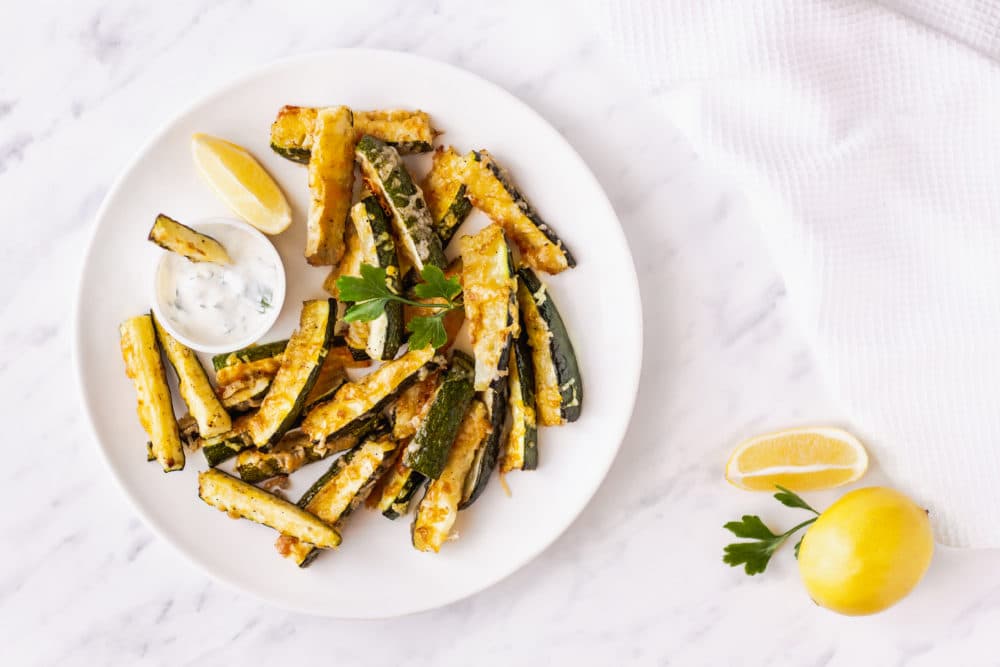 zucchini-bites-on-a-white-plate-with-a-bowl-of-dip-on-the-side