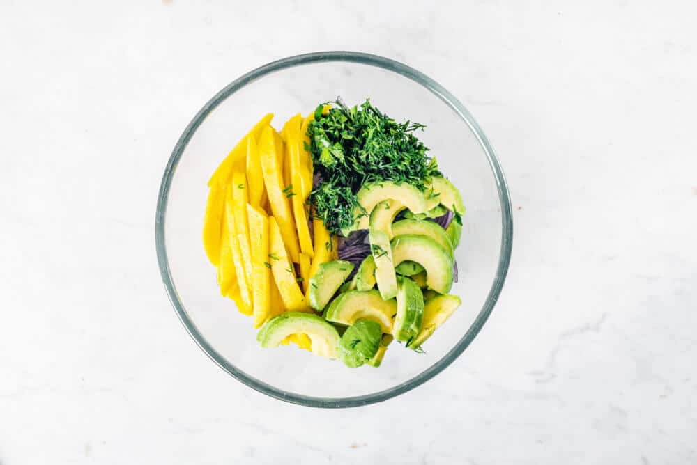 Chopped ingredients in a glass bowl ready to be mixed.