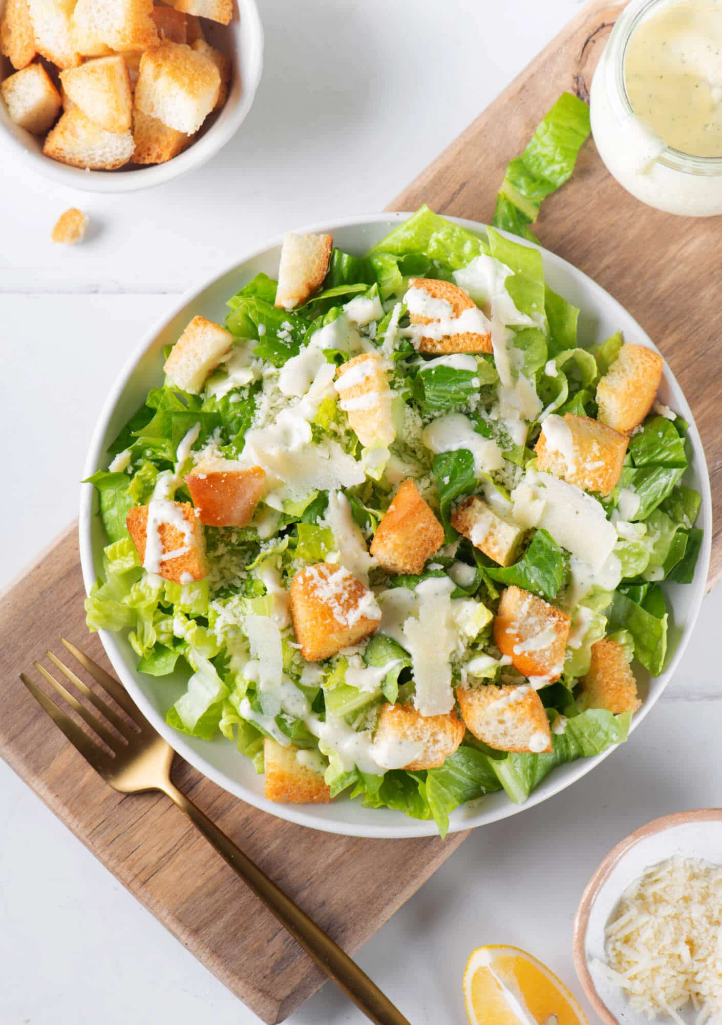 caesar-dressing-in-a-white-bowl-with-a-fork-on-a-wooden-board