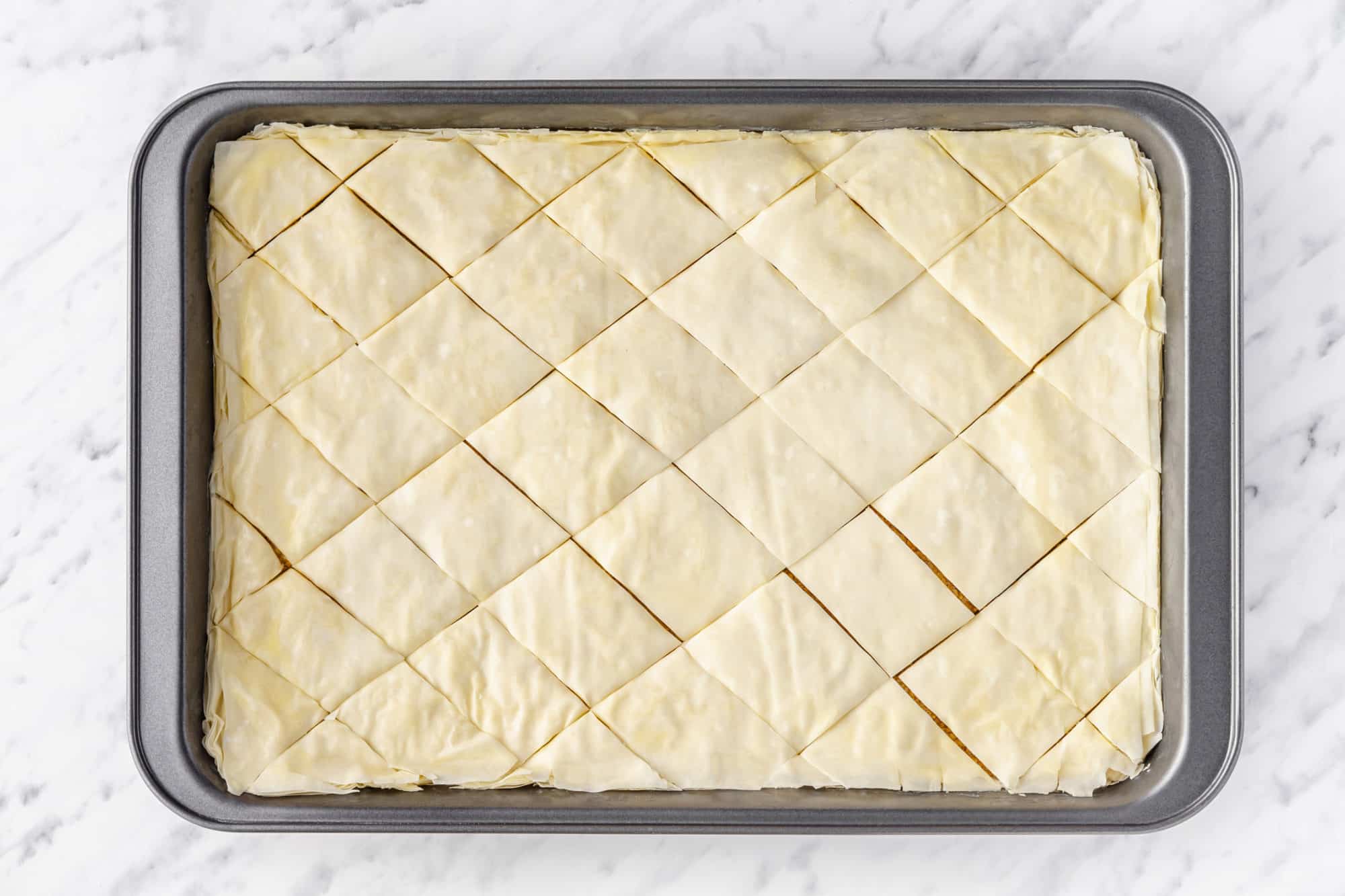 prepared baklava cut in a baking tray.