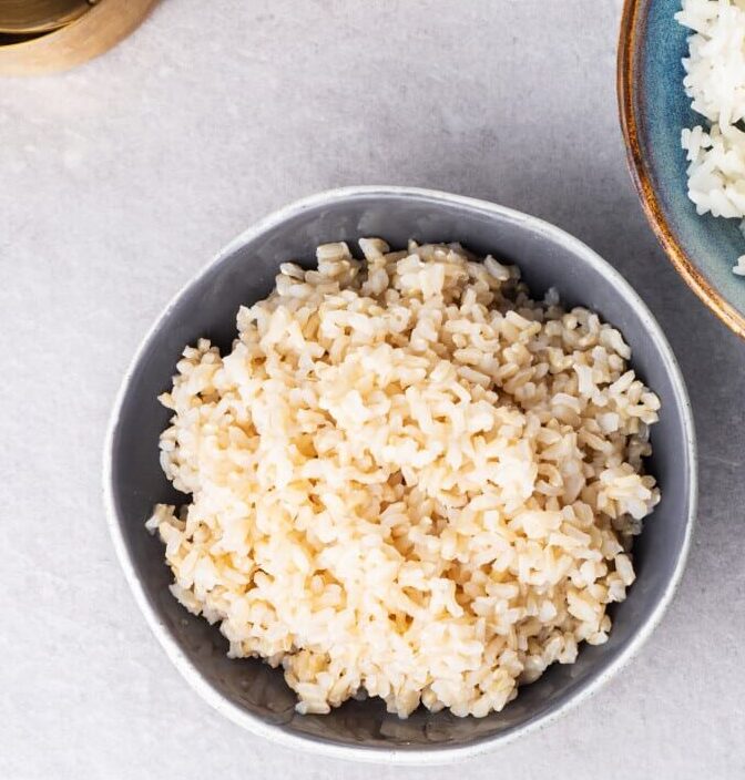 A grey bowl filled with cooked brown rice.