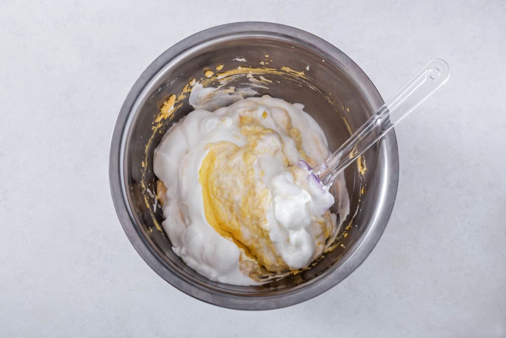 pecan-torte-batter-being-mixed-with-egg-whites-in-a-silver-bowl-with-a-spatula